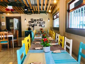 コミタン・デ・ドミンゲスにあるHotel Casa Caelumのダイニングルーム(長いテーブル、黄色と青の椅子付)