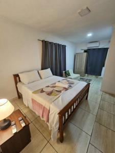 a bedroom with a large bed with two cupcakes on it at Alpha & Omega Apartment Seychelles in Beau Vallon