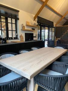 un grande tavolo in legno con sedie in una stanza di Gastenverblijf A&A met mezzanine a Gavere