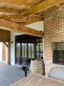 un patio con pared de ladrillo y techo de madera en Gastenverblijf A&A met mezzanine, en Gavere