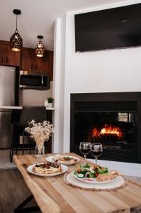 a table with two plates of food and wine glasses at Suite 104- Destination Mont-Orford in Magog-Orford