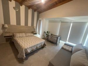 een slaapkamer met een bed en een bank bij Balcón al río in Villa Carlos Paz