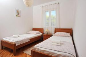 ein Schlafzimmer mit zwei Betten und einem Fenster in der Unterkunft Apartment Mariner in Sutivan