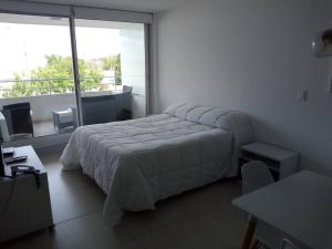 - une chambre avec un lit et une grande fenêtre dans l'établissement Departamentos en Uruguay al río, Dos Orillas, Dazzler, Colonia, à Colonia del Sacramento