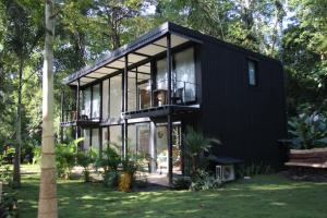 a black house with glass walls and trees at Green Lapa's in Puerto Viejo