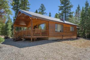 a log cabin with a large porch and a deck at Duck Creek Village Cozy Cabin Near Fishing and ATV in Duck Creek Village