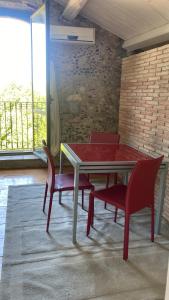 Il Casale في Marano Marchesato: غرفة طعام مع طاولة حمراء وكراسي