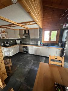 una cucina con armadi bianchi e soffitto in legno di Superbe chalet 12 personnes vue imprenable 2nuits min ad Anzère