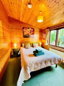 1 dormitorio con 1 cama en una habitación de madera en 'Mallard' Secluded Rustic Lodge - Digital Detox Paradise, en Allerthorpe