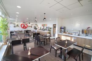 um restaurante com mesas e cadeiras e um balcão em Holiday Inn Express Strasbourg - Sud, an IHG Hotel em Geispolsheim