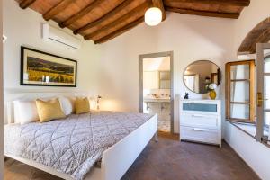 1 dormitorio con 1 cama grande y espejo en Villa Cantucci, en Volterra