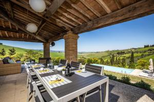 una mesa de comedor en un patio con vistas a las colinas en Villa Cantucci, en Volterra