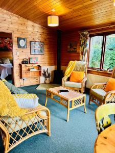 a living room with couches and chairs and a table at 'Mallard' Secluded Rustic Lodge - Digital Detox Paradise in Allerthorpe