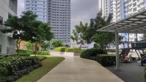 a walkway in a city with tall buildings at The Grass Residences in Manila