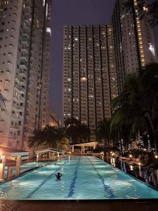 マニラにあるThe Grass Residencesの高層ビルが立ち並ぶ都市の大型スイミングプール