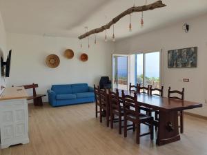 Una sala de estar con una mesa y un sofá azul. en Villetta Muntelgu, en Castelsardo