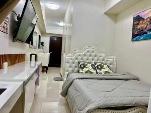 a bedroom with a bed and a sink and a television at Angels Nest in Camella Northpoint Condominium Studio & 2 bedrooms Unit in Davao City