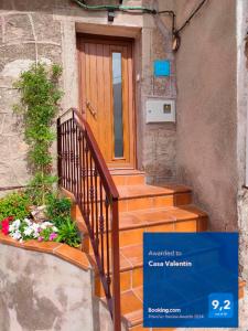 a house with a wooden door and stairs with flowers at Casa Valentín in Casillas