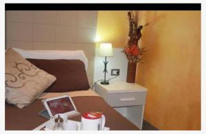 um quarto com uma cama e uma mesa com um candeeiro em Sabrina Airport em Fiumicino