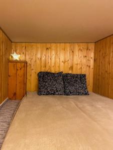 um quarto com uma cama numa parede de madeira em Penzión IMRICH CAR em Presov