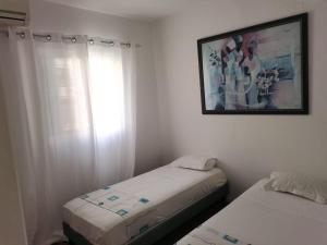 a bedroom with two beds and a picture on the wall at Appartement Sao Filipe in Praia