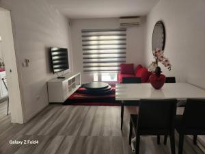 a living room with a table and a red couch at Appartement Sao Filipe in Praia