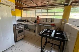 a kitchen with a stove and a table in it at Sítio Pousadinhas do Lago in Almeida