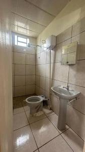 a bathroom with a toilet and a sink at Sítio Pousadinhas do Lago in Almeida