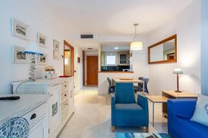 uma cozinha e sala de estar com uma cadeira azul e uma mesa em Apartamento en S'Abanell Central Park em Blanes