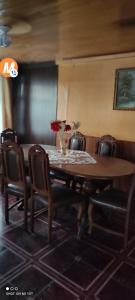 una mesa de comedor con sillas y un jarrón de flores. en CASA PUERTO MONTT en Puerto Montt