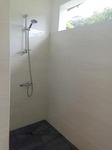 a shower stall in a bathroom with a window at Camping TENUI in Taputapuapea