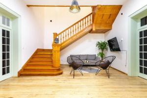 a living room with a staircase and a couch and chairs at UCO Live Roma in Mexico City