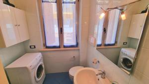 a bathroom with a toilet sink and a washing machine at MARZIO - appartamenti con terrazzo, posto auto e spiaggia in Marcelli +27 photos