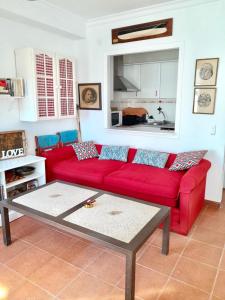 ein Wohnzimmer mit einem roten Sofa und einem Tisch in der Unterkunft Las Casas de Mar Zahara de los Atunes in Zahara de los Atunes