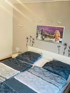 - 2 lits dans une chambre avec une photo sur le mur dans l'établissement Ferienwohnung Fera, 