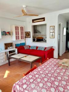 ein Wohnzimmer mit einem roten Sofa und einem Tisch in der Unterkunft Las Casas de Mar Zahara de los Atunes in Zahara de los Atunes