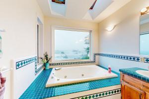 a bathroom with a tub and a window at Pebble Beach Bliss in Crescent City