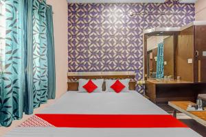 a bedroom with a bed with red pillows and a mirror at Flagship Hotel Royal in Rānchī