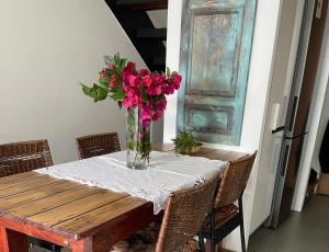 einen Tisch mit einer Vase rosa Blumen drauf in der Unterkunft Loft Cerro Alegre Valparaíso in Valparaíso