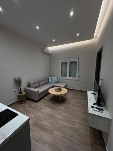 Central Stylish Lux Apartments في لاميا: غرفة معيشة مع أريكة وطاولة