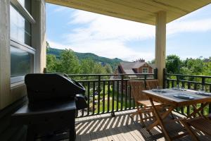 a screened in porch with a table and a grill at Tremblant Prestige - Les Eaux 227-3 in Mont-Tremblant +27 photos