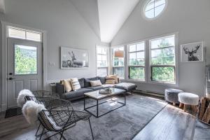 a living room with a couch and chairs and windows at Tremblant Prestige - Les Eaux 227-3 in Mont-Tremblant