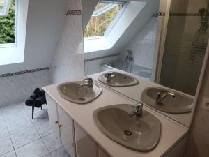 a bathroom with two sinks and a mirror at La Fontaine Aux Enfants - Chambre avec sdb privée in Abreschviller