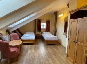 a room with two beds and a table and chairs at Hotel King George in Prague