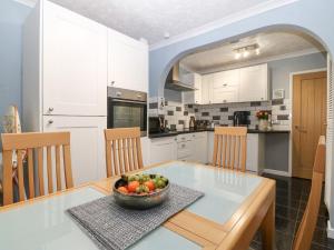 a kitchen with a bowl of fruit on a table at Normandy in Nefyn