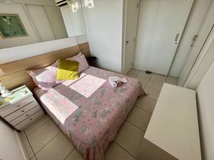 Dormitorio pequeño con cama con manta rosa en UNU Rio Vermelho: Piscina, vaga, wifi, academia, +, en Salvador