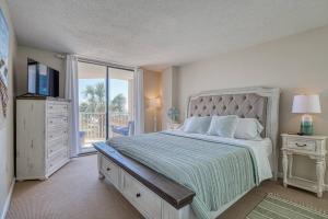 1 dormitorio con 1 cama grande y balcón en Oceanfront Oasis: Endless Ocean Views & Luxury Amenities Minutes to Attractions en Myrtle Beach