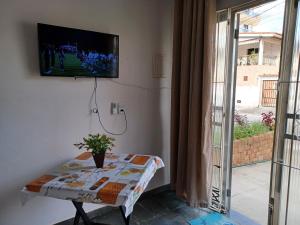 Habitación con mesa y TV en la pared. en PRAIA DO FORTE a 5 Min de carro - PRAIA DAS DUNAS BRAGA a 7 Min a pé - WI FI en Cabo Frío