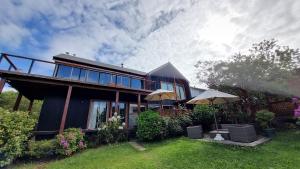 a house with two umbrellas in the yard at Hostel Torobayo in Valdivia