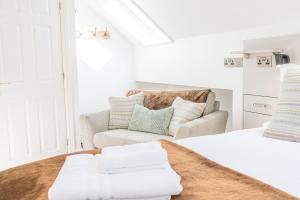 a white bedroom with a couch and a bed at Romantic getaway in this stylish studio with views and free parking in Burneside